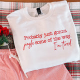 White sweatshirt with red text and red and white striped shorts on a plaid fabric background.